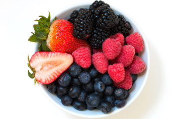 Organic fresh mixed berries fruit in a bowl on the table.