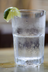 Glass of water with condensation and lime wedge