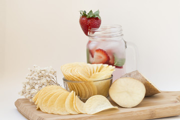 Potato chips on wooden block.