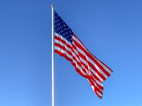 American flag waving in blue sky.