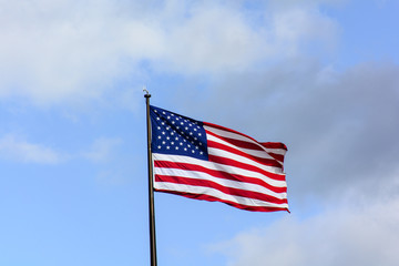 Fototapeta premium USA flag wave in the wind under blue sky