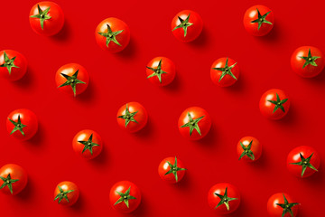 Cherry tomato pattern on a red background. Flat lay, top view