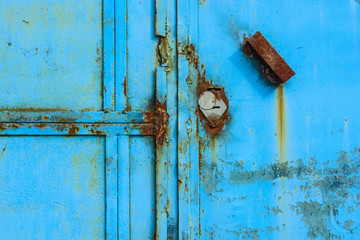 Old rusty metal door painted blue