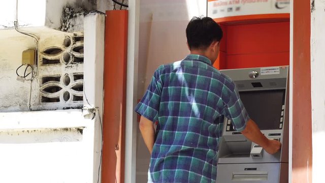 Man withdraw cash from ATM.

