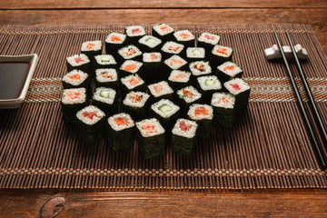 Delicious and tasty set of japanese sushi served on straw mat, closeup. Maki rolls, art food, luxury restaurant menu photo. National oriental seafood.