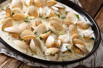 Stewed clam in a creamy sauce with herbs and garlic close-up. horizontal