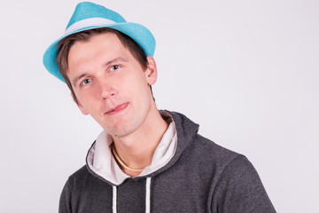 Charming handsome young man in formalwear Holds a blue hat white background