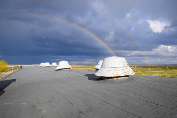 Fototapeta na wymiar Rainbow, view from the roof of the building. Ventilation outlets