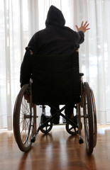 person in a wheelchair in his bedroom