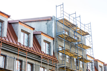 Fototapeta na wymiar scaffolding near house under construction. facade renovation.