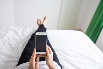 Man in his bed at home looking at mobile phone