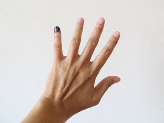 Inked pinky finger of a woman's hand. Purple ink blots from voter's finger provides evidence of the governor election (pilkada) in Jakarta, Indonesia.