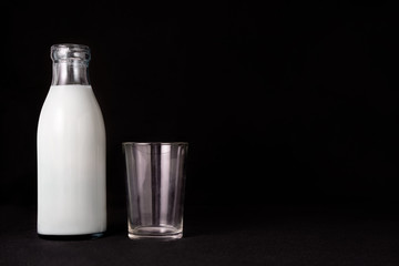 Bottle of milk  glass black background copy space