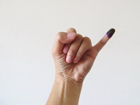 Inked pinky finger of a woman's hand. Purple ink blots from voter's finger provides evidence of the governor election (pilkada) in Jakarta, Indonesia.