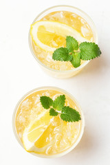 Two glasses of whiskey, ice, mint and lemon top view.