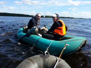 Girl teenager  in orange  life jacket with grandfather fishing on rubber boats