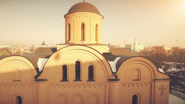 4K Aerial Top Drone View: architectural monument of the 12th century, Church of the Assumption at Podol in Kiev, Ukraine. Downtown, city central. Vintage yellow toning in retro style. Camera rise up