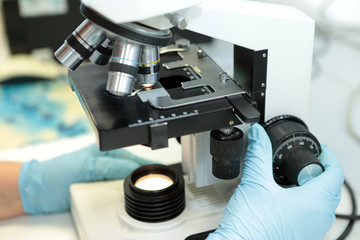 Medical microscope. Professional pharmaceutical microscope. Study of the properties of the drug when increasing. The person analyzes the components of the medicine.