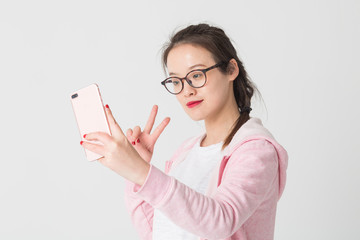 Portrait of beautiful young woman playing her mobile phone,taking selfie.