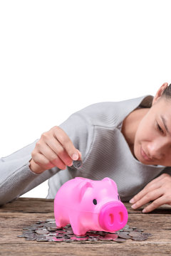 Woman inserting coin in a piggy bank