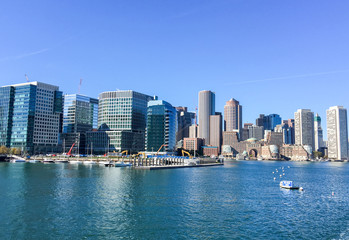 Fototapeta na wymiar BOSTON - OCTOBER 2015: City port and buildings on a sunny day. Boston attracts 10 million people annually