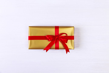 Gift box with red bow. Golden present package.