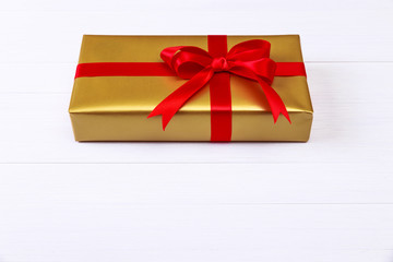 Gift box with red bow. Golden present package.