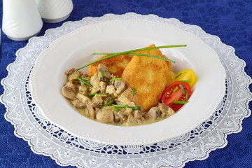Potato patties with creamy mushroom sauce in a white plate on a blue cloth. Healthy food concept