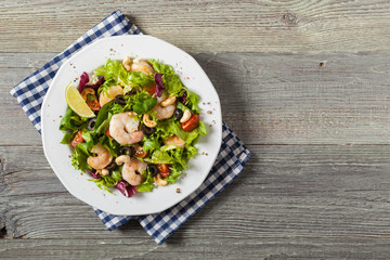 Shrimp salad with tomato, olives and cashew nuts.