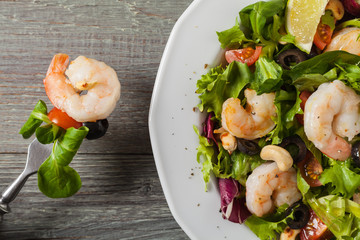 Shrimp salad with tomato, olives and cashew nuts.
