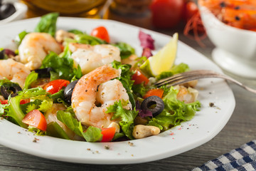 Shrimp salad with tomato, olives and cashew nuts.