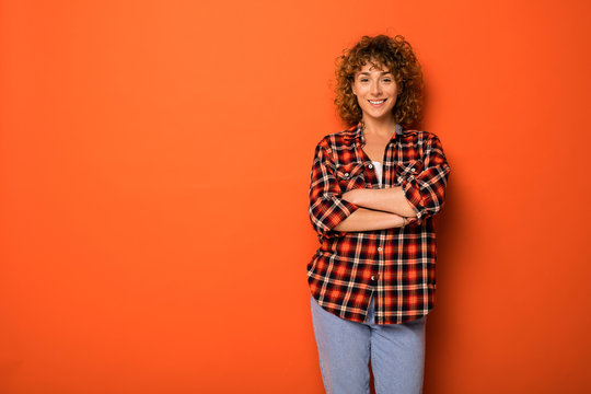 Young Natural Curly Woman Standing Over An Orange Background