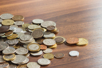 Different gold and silver collector's coins on the wooden table