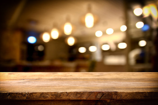wooden table in front of abstract restaurant lights background