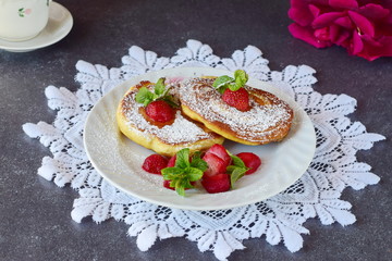 Pancakes with strawberry inside in a white plate on a white lace textile. Healthy breakfast. Healthy eating concept