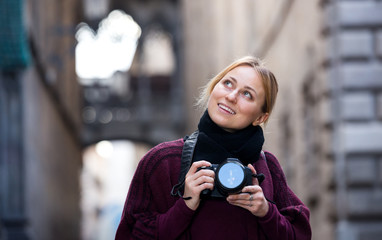 Fototapeta premium Girl holding camera in hands and photographing