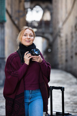 Young woman looking and taking pictures outdoors