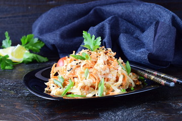 Korean traditional kitchen. Raw marinated chicken in soy sauce, spices, onions and carrots on a black plate on a dark background. Healthy food. Healthy eating concept