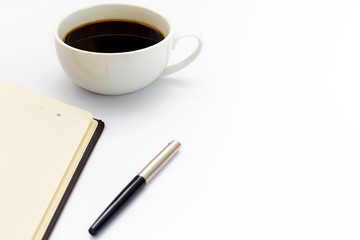 Cup of black coffee, pen and diary on white background. Minimal business concept. Flat lay.