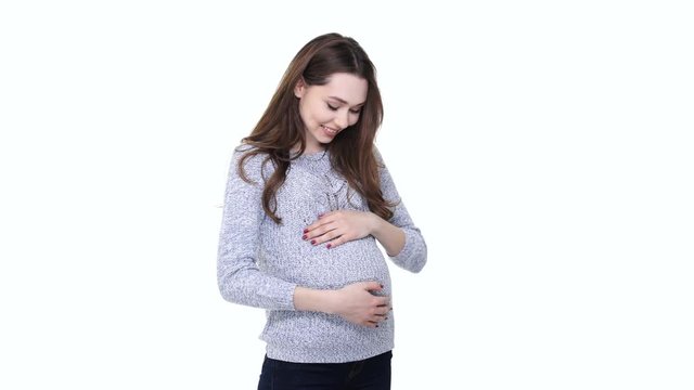 Happy pregnant woman expecting a baby and showing thumbs up gesture isolated over white