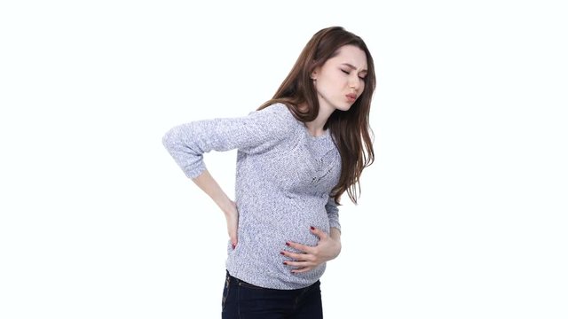 Tired depressed pregnant woman holding her back and feeling exhausted isolated over white
