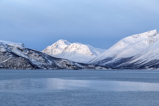Blue sky and snowy peaks surround the cold sea Lyngen Alps Troms&Atilde;&cedil; Lapland Norway Europe
