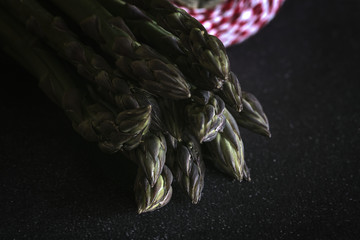 Fresh green asparagus on black wood table