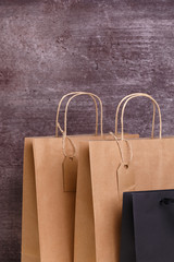 Mockup of blank shopping bags. Brown and black craft packages. Concept for sales or discounts. Recycled paper. Wooden rustic board.