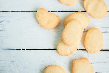 A group of butter shortbread cookies on white wooden background. Selective focus. Close up and copy space.