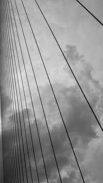 Fototapeta Sling of bridge with beautiful sky, hanging structure. Shoot in black and white shot.