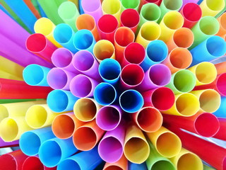 Abstract background from end of multicoloured plastic drinking straws close up, as sign for heterogeneity or teamwork.  Selective focus.