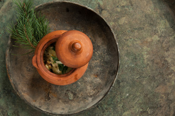 dish in a clay pot on an old antique tray