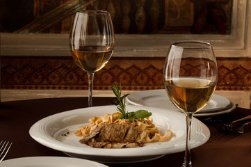 served table with a meat dish and a glass of wine on the background of the picture