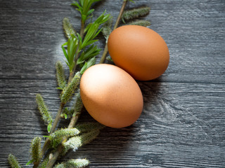 eggs and willow twigs on wooden background